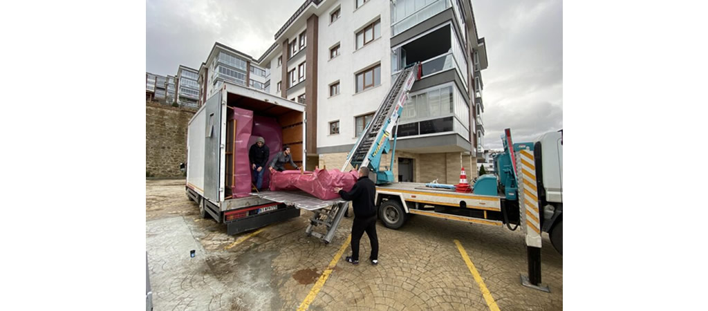 Asansörlü nakliyat aracıyla yüksek katlı binadan eşya taşıma işlemi.